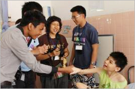 ホーチミン市立ツーズー病院の子どもたちと言葉を交わす日本の大学生とタイの大学生