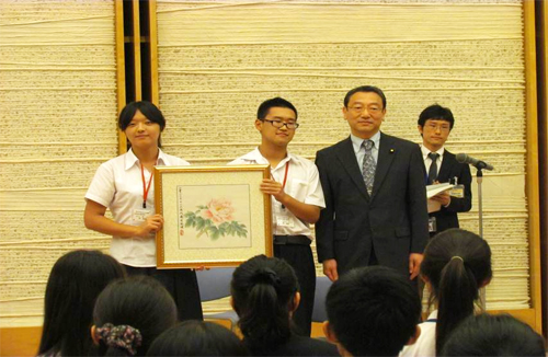 首相官邸訪問で、長浜官房副長官に記念品を贈呈する北京の高校生