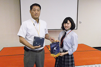 ジェトロ伊藤アドバイザーに記念品を贈呈する日本高校生