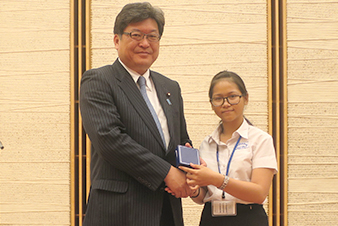 萩生田官房副長官にプレゼントを渡すカンボジア高校生の代表