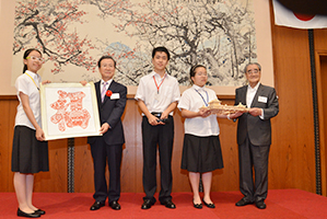 中国高校生より程永華大使(左)、岡田名誉会長(右)へ記念品の贈呈