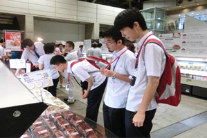 イオンのプライベートブランド(トップバリュ)商品 の展示会を見学する中国の高校生