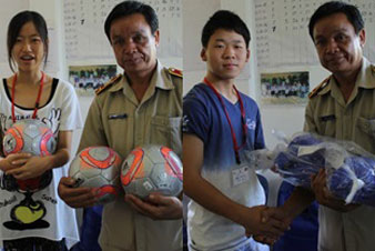 サッカーボールと袋に入った大縄跳びを贈呈する日本高校生