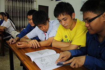 体操を披露する小学校の生徒たち地理の授業でラオス高校生(右)から説明を受ける日本高校生