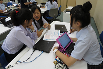 英語の授業でグループワークについてペアに説明する日本高校生