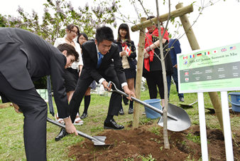 日本高校生と一緒に植えた木に土をかけるカナダ代表の参加者