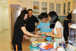 ホストファミリーと春巻き(ベトナムの伝統的な料理)を作る日本の高校生