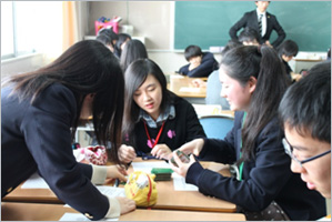 盛岡中央学校にてカードを使っての交流ゲームをする両国の学生