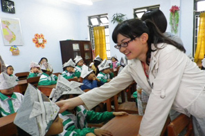 ベトナムの子どもたちに日本の伝統遊び、かぶとづくりを教える日本人参加者