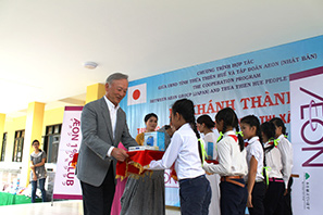 子どもたちに文具を贈呈する加藤憲HD加藤会長(左)と令夫人(右)